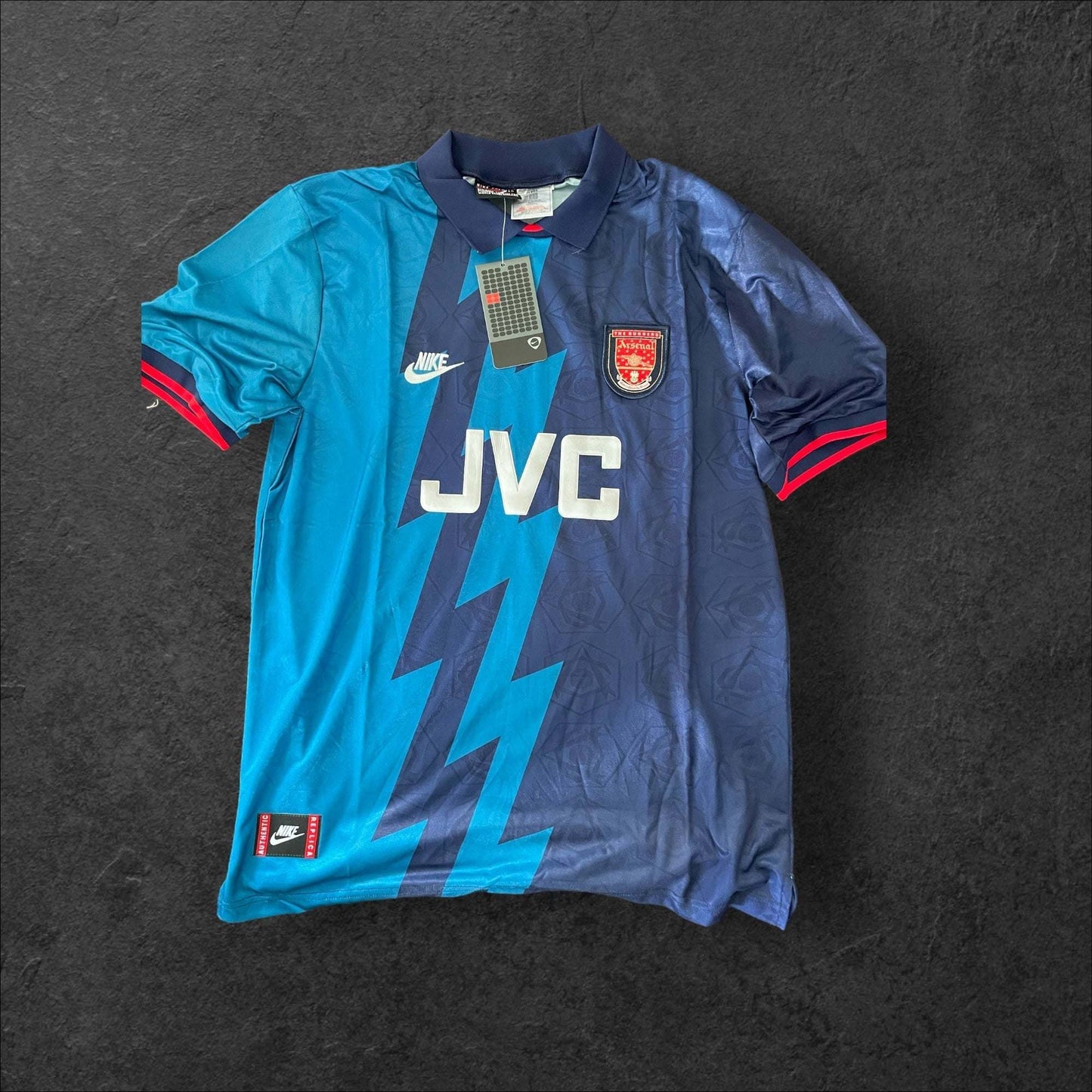 Arsenal Away 1995-96 football jersey with navy and teal lightning pattern, classic crest, and sponsor logo.